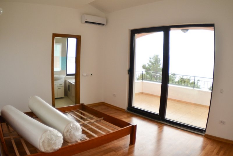 Bedroom in a house in Shushan, Montenegro: wooden bed, access to a terrace with a view, and a private bathroom.