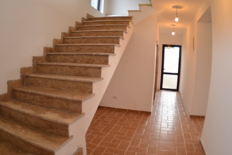 Staircase with stone finishes in a house in Shushan, Montenegro: bright interior with tiled floors and access to the street.