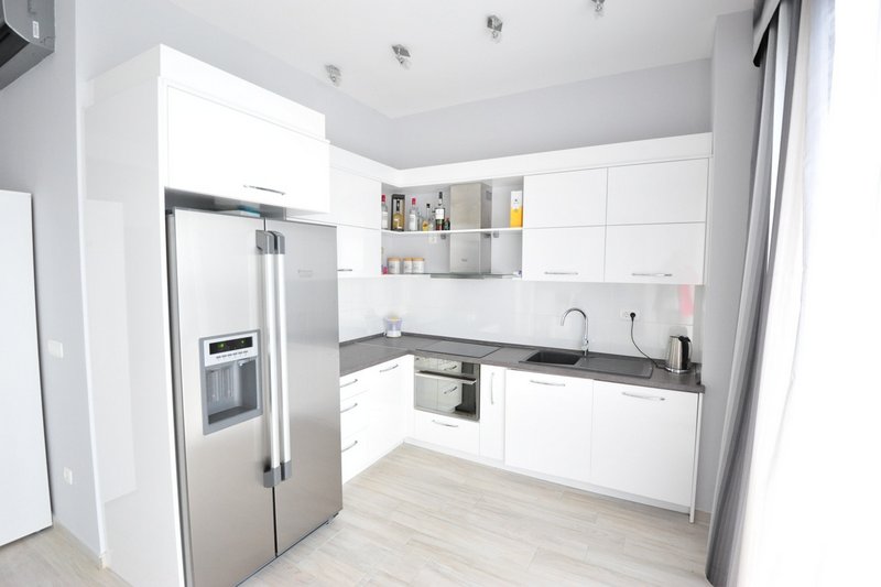 Modern white kitchen with appliances in an apartment, Dobri Vody, Montenegro: built-in refrigerator and bright interior.