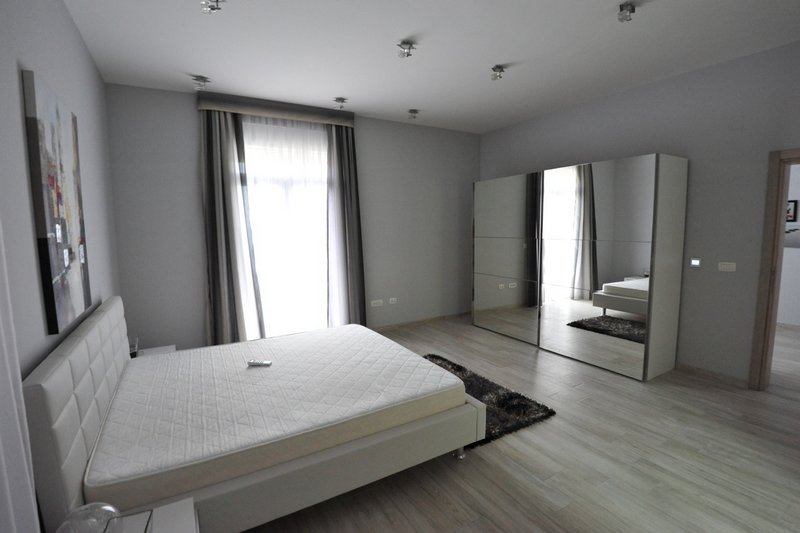 Modern bedroom with a double bed and mirrored wardrobe in an apartment, Dobri Vody, Montenegro.