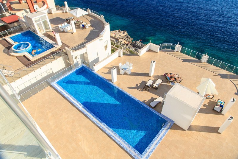 An outdoor pool on the terrace of a luxury apartment in Dobri Vody, Montenegro, with panoramic views of the Adriatic Sea.