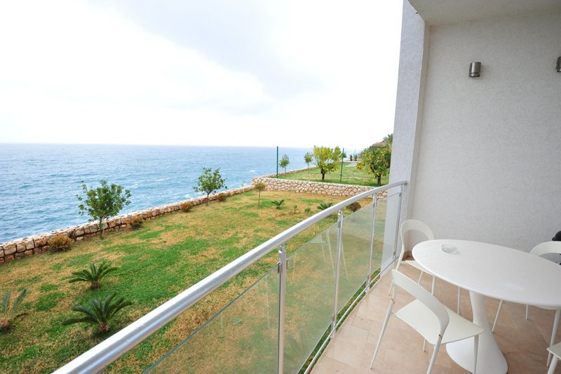 Balcony with white furniture and panoramic sea view in an apartment, Dobri Vody, Montenegro.