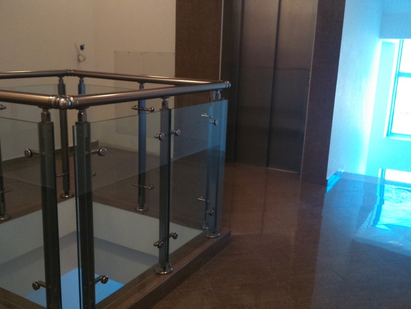 Modern lobby with elevator and glass staircase railing in a residential complex, Budva, Montenegro.