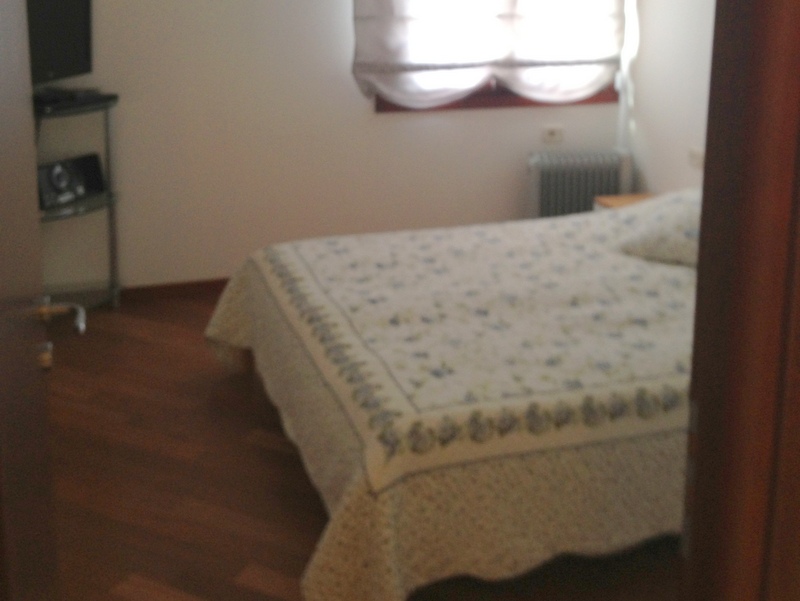 Cozy bedroom with a double bed and parquet flooring in an apartment for sale in Budva, Montenegro.