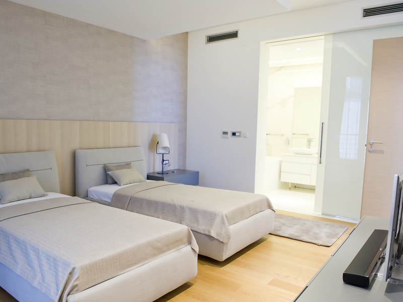 Modern bedroom with two beds in Dukley apartments, Bečići, Montenegro: stylish interior and private bathroom.