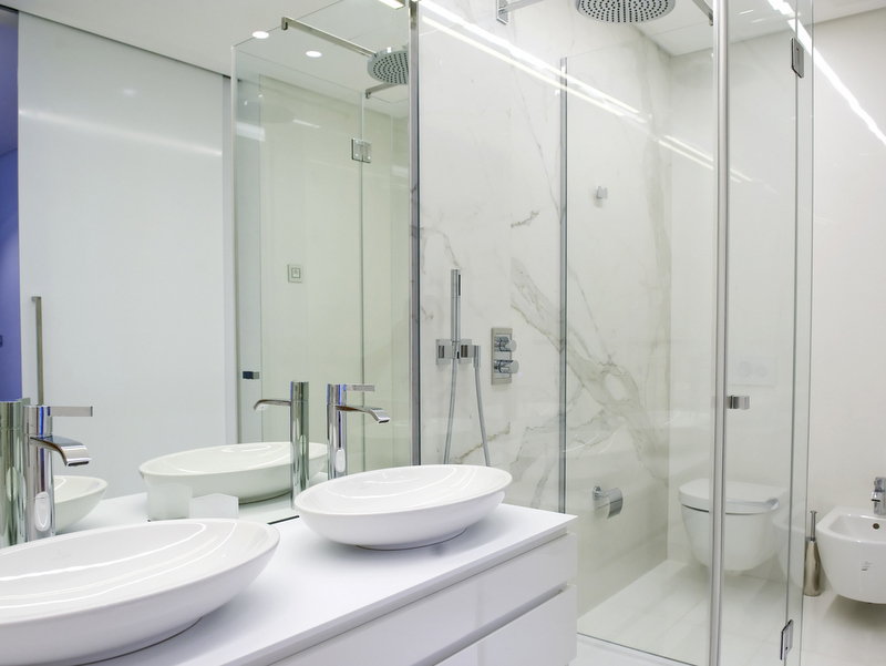 Modern bathroom with marble-look finishes in Dukley apartments, Bečići, Montenegro: two sinks and a shower.