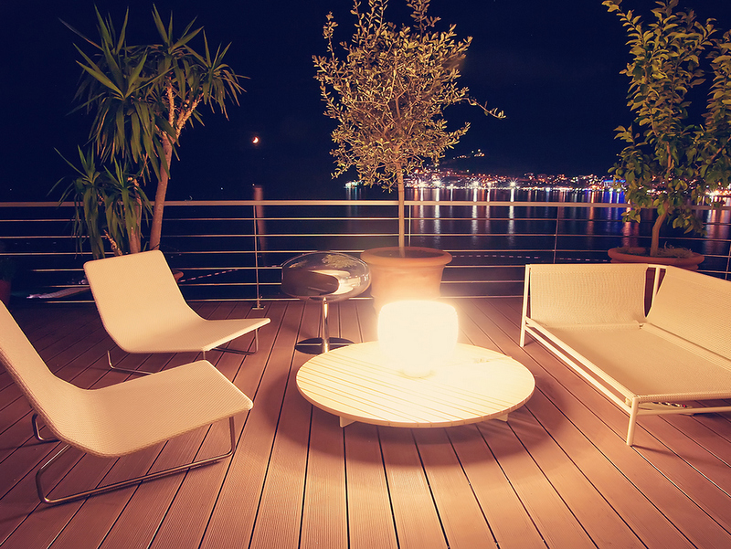 Terrace with furniture and sea view in the Dukley complex, Becici, Montenegro: night lighting and modern design.