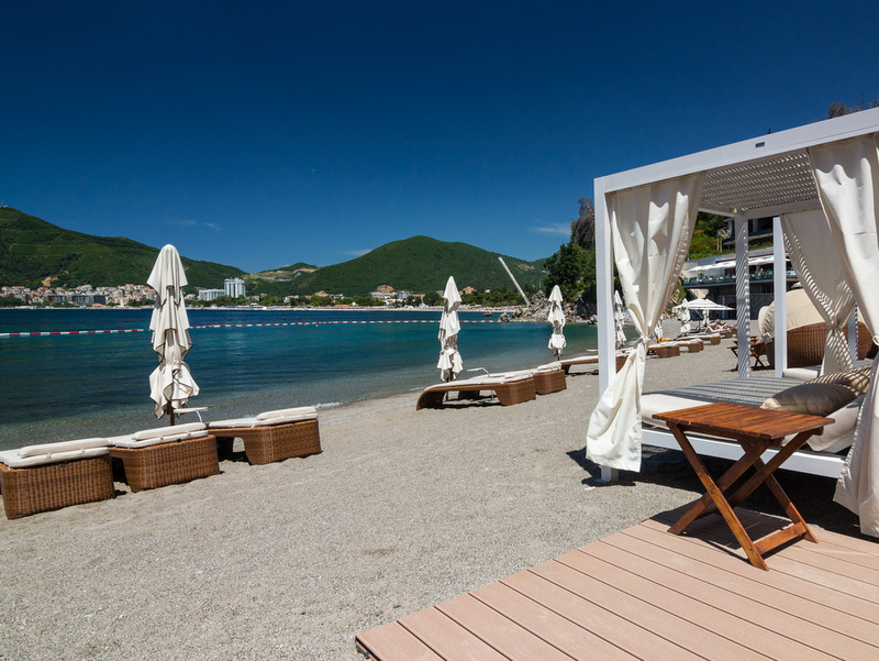 Dukley Gardens beach in Bečići, Montenegro: sun loungers, canopy cabanas, and a view of the Adriatic Sea.