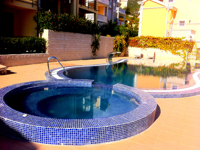 Outdoor pool and jacuzzi with blue mosaic in a residential complex in Bečići, Montenegro.