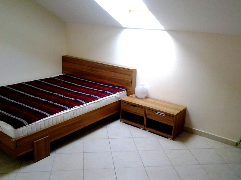 Bedroom in a loft apartment in Bar, Montenegro: double bed, nightstands, and a skylight in light tones.
