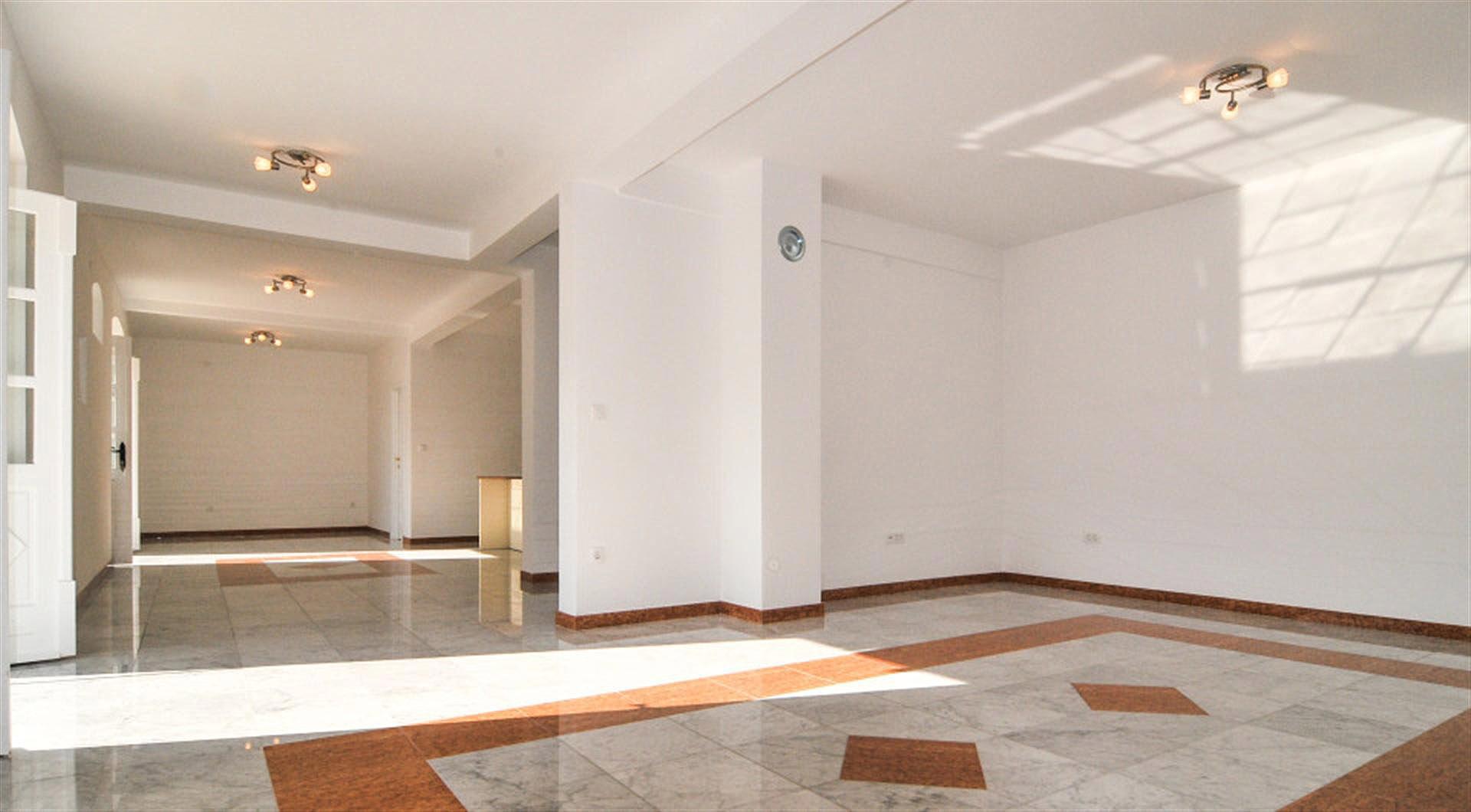 Spacious bright living room with marble floor in a villa, Drazin Vrt, Montenegro. Interior with white walls.