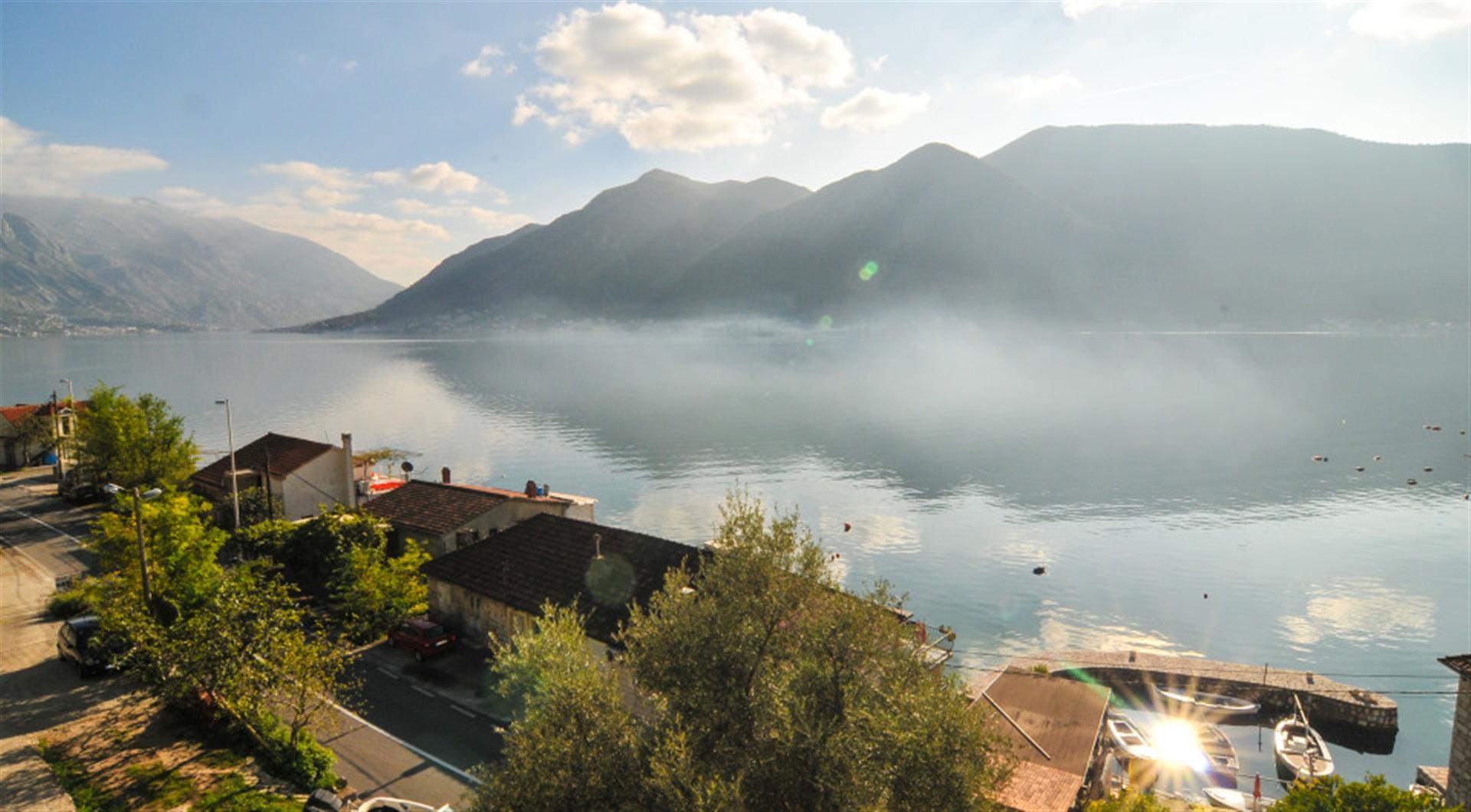 Panoramic view of the Bay of Kotor and mountains from a villa in Dražin Vrt, Montenegro: coastline and boat pier.
