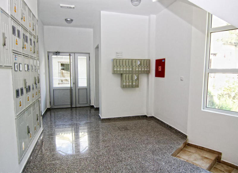 Bright apartment building entrance in Bečići, Montenegro: granite floor, mailboxes, and a glazed entrance area.
