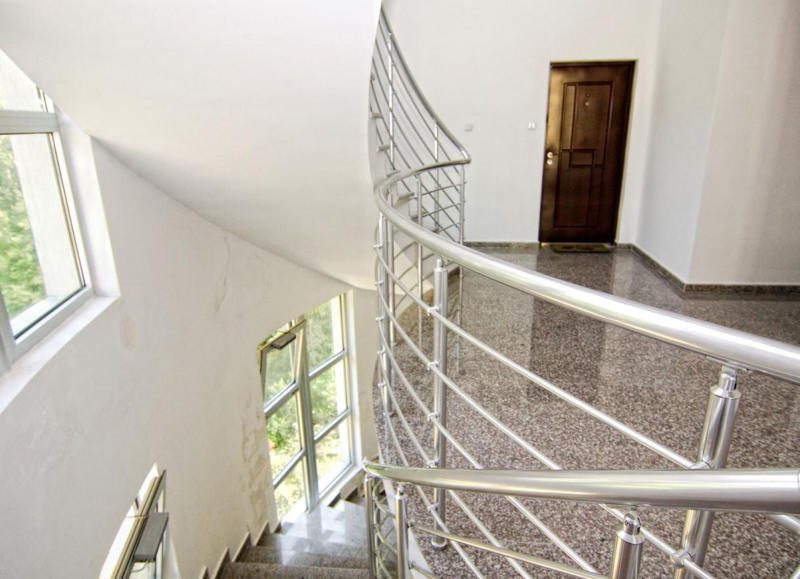Spiral staircase with metal railings and granite floor in an apartment, Bečići, Montenegro.