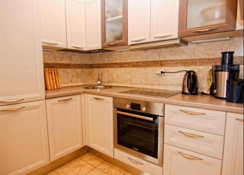 Bright kitchen with modern appliances in an apartment in Bečići, Montenegro: built-in oven and cooktop.