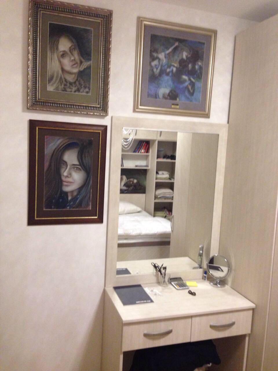 Vanity table with mirror and paintings in the bedroom of an apartment in Bečići, Montenegro. Cozy interior with light wood furniture.