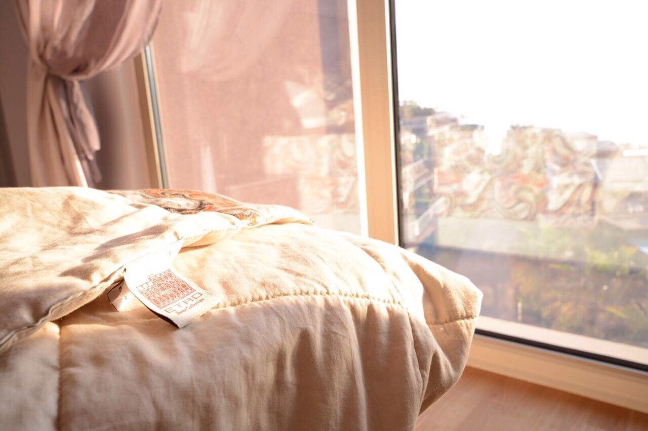 Cozy bedroom with a panoramic window and sea view in an apartment in Becici, Montenegro, with high-quality Etro textiles.