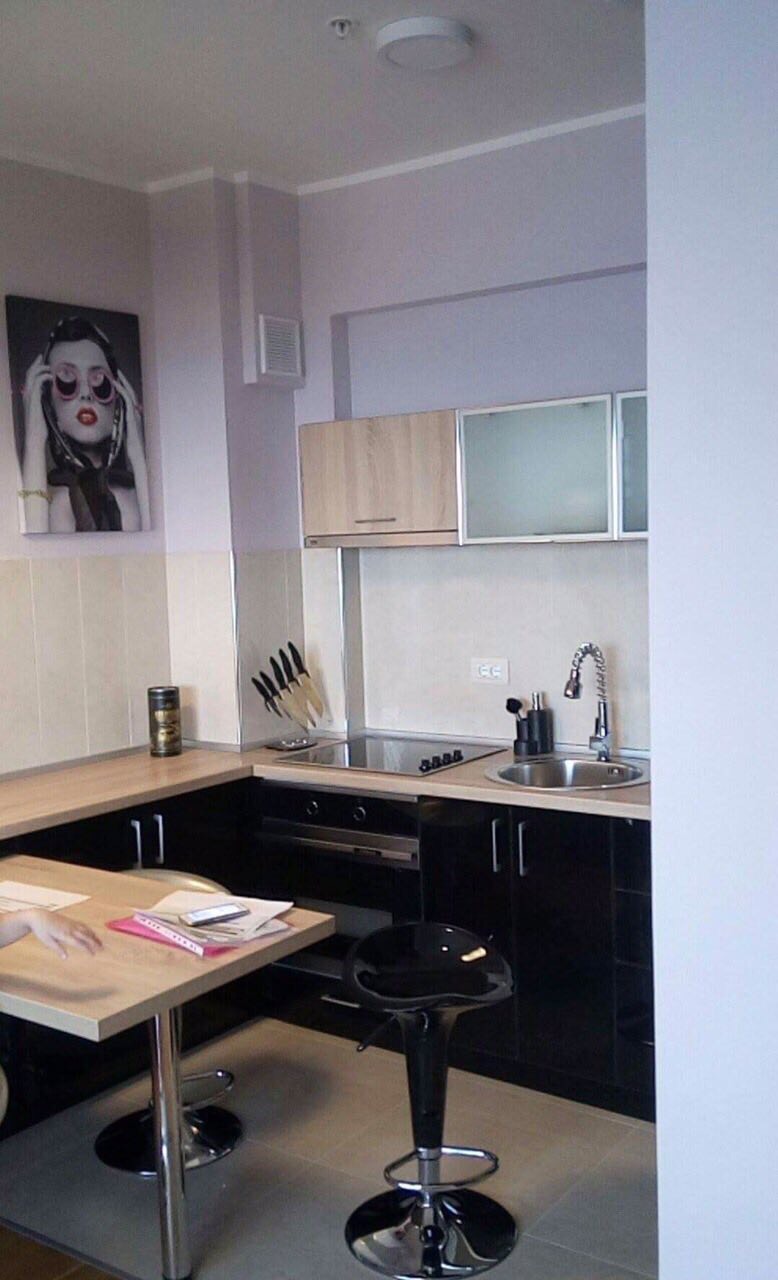 Modern kitchen in an apartment in Bečići, Montenegro: black cabinetry, a breakfast bar, and built-in appliances.