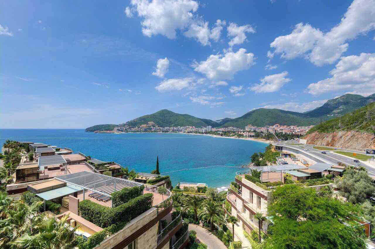 View of a modern residential complex with terraces and panoramic sea and beach views in Bečići, Montenegro.