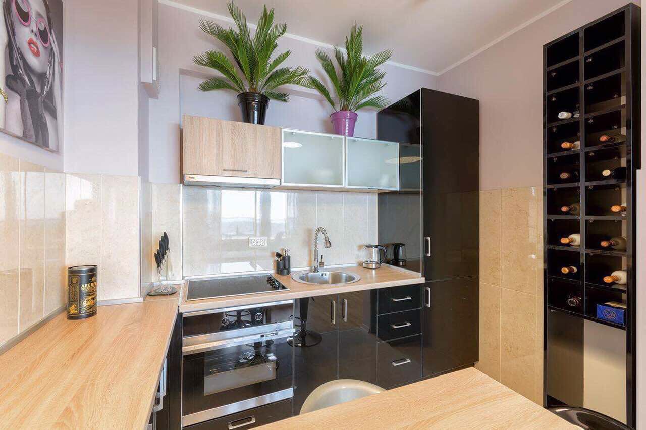 Modern kitchen in an apartment in Bečići, Montenegro: black cabinetry, built-in appliances, and a wine rack in the interior.