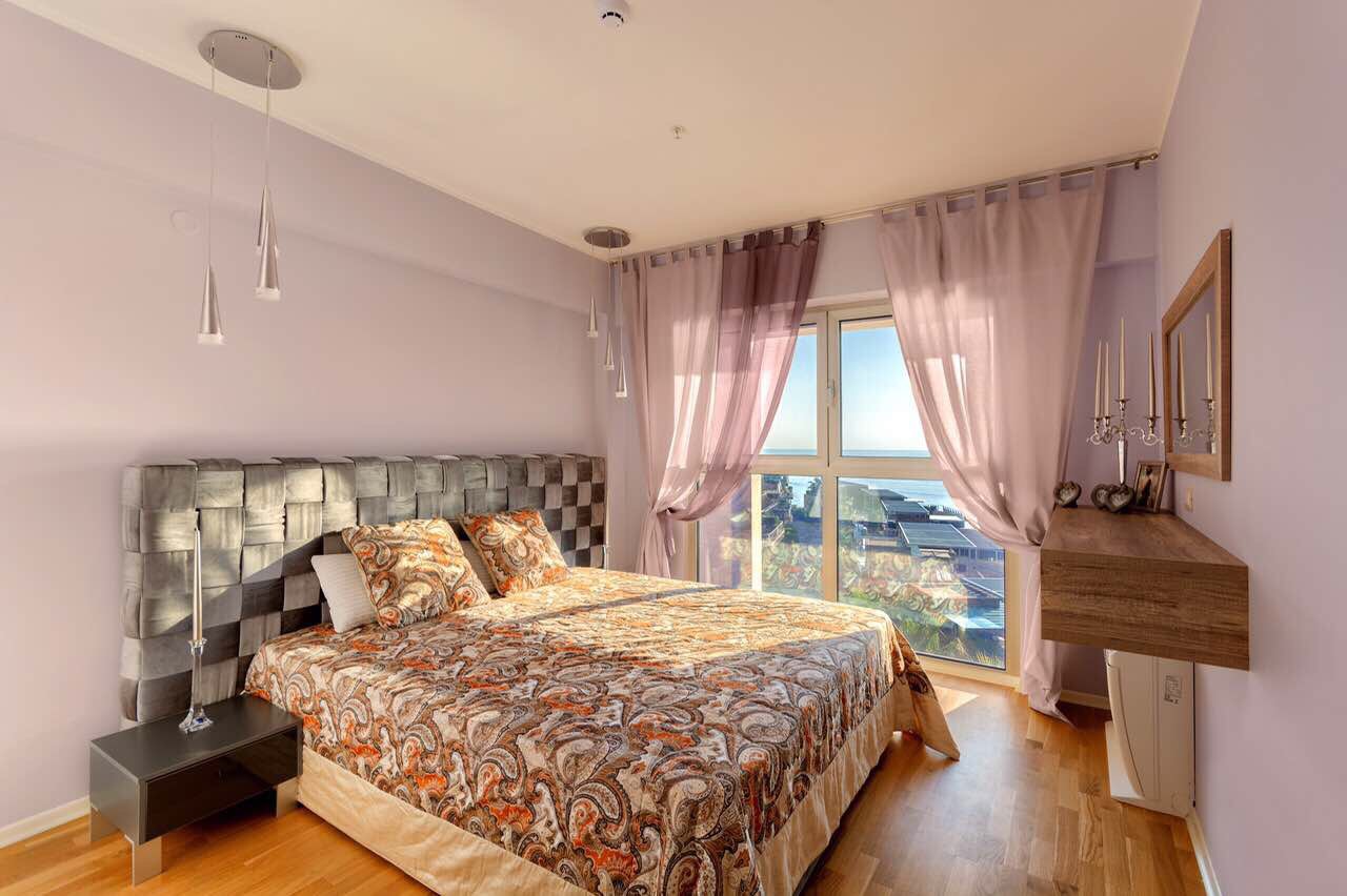 Cozy bedroom with a double bed and sea view in an apartment in Bečići, Montenegro. Modern interior.