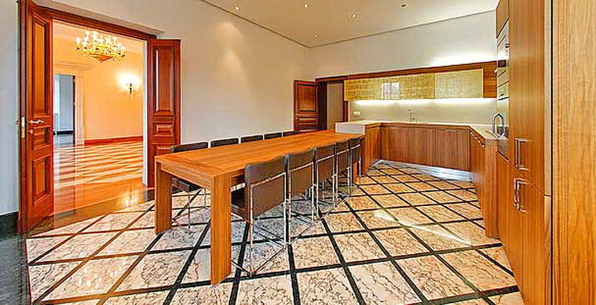 Kitchen with wooden furniture and marble flooring in a villa in Dobrota, Montenegro: modern interior and dining area.