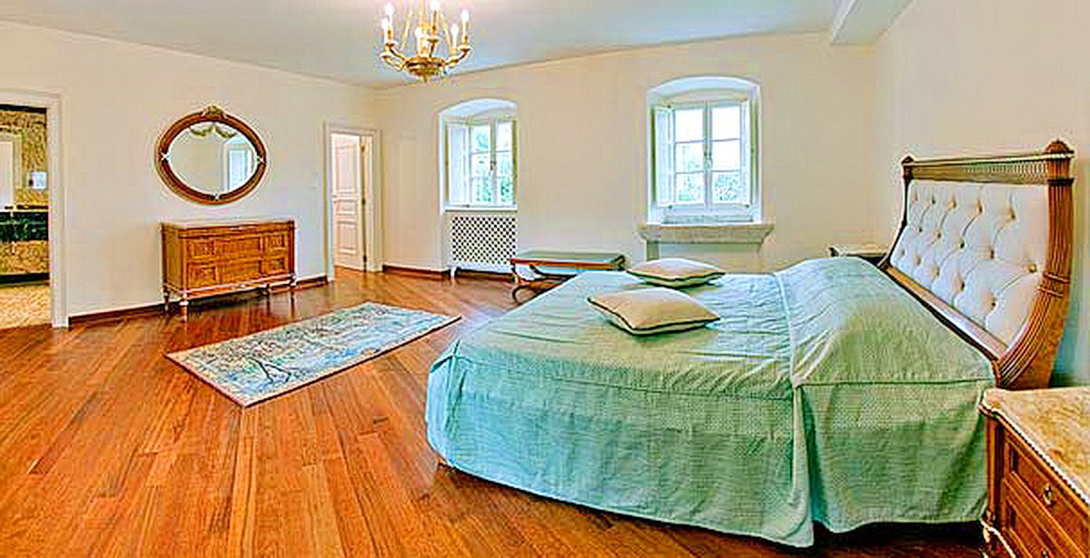 Spacious bedroom with a double bed and parquet flooring in a villa in Dobrota, Montenegro. Classic interior with a dresser.