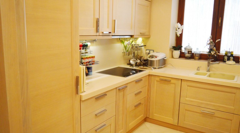 Bright wooden kitchen with modern appliances in a villa in Tivat, Montenegro: built-in cooktop and sink.