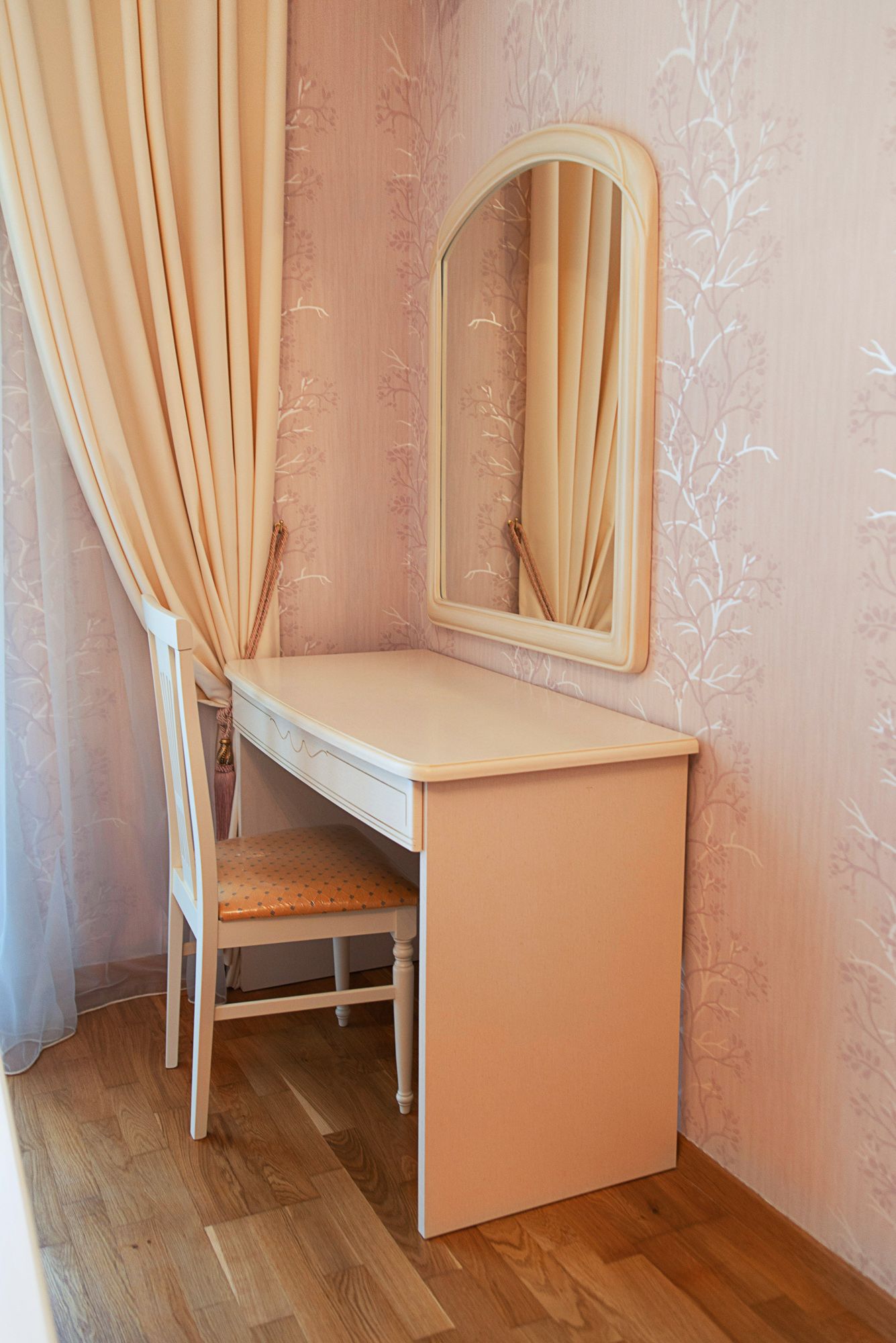Vanity table with mirror and chair in the bedroom of a townhouse in Lastva, Montenegro, with classic wall finishes.