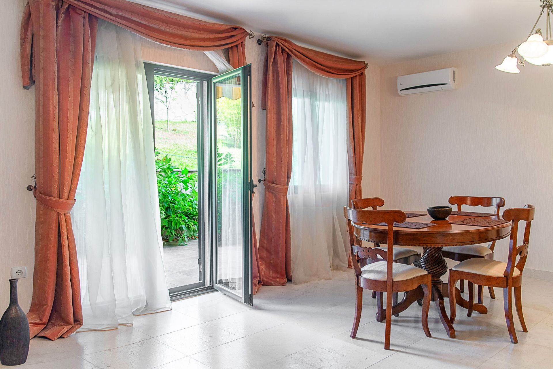 Living room with dining area and access to the terrace in a townhouse, Lastva, Montenegro: wooden table, light flooring.