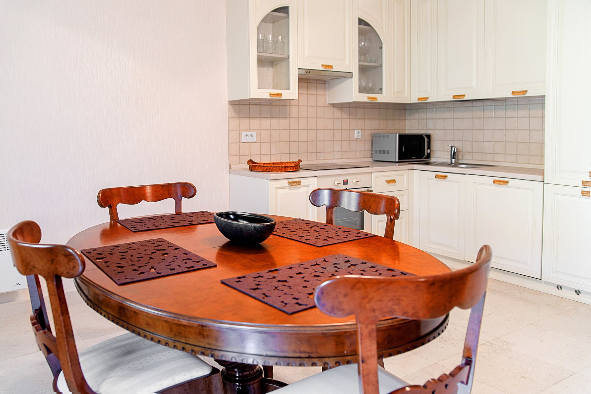 Kitchen with a white cabinet set and a wooden dining table in a townhouse, Lastva, Montenegro.