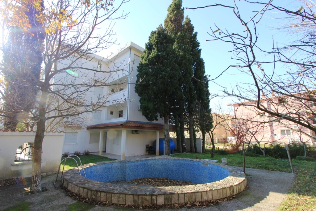 Mini-hotel in Sutomore, Montenegro: view of the building with an outdoor pool, cypress trees, and landscaped grounds.