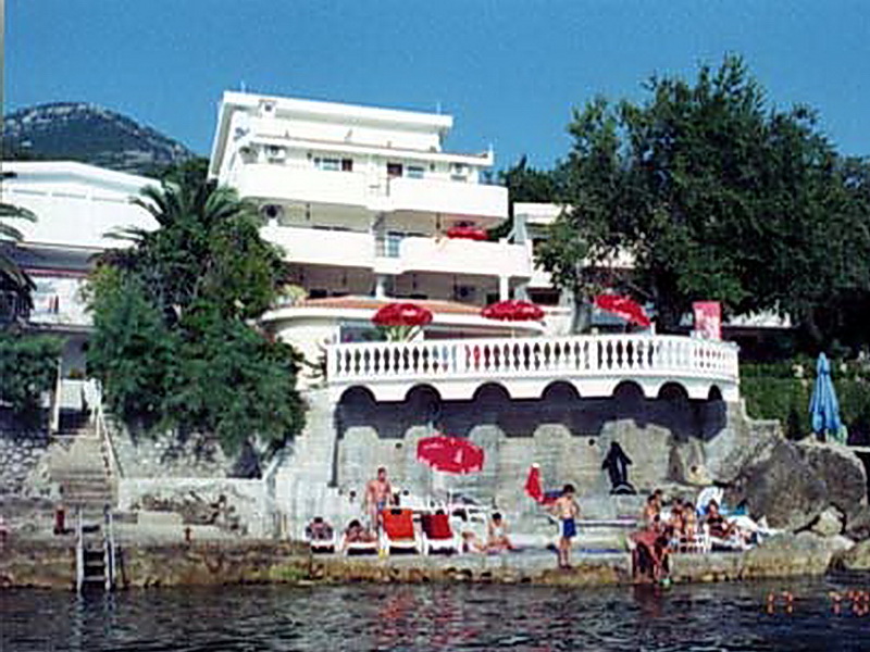 White hotel on the seafront in Sutomore, Montenegro, with a private terrace, balustrade, and beach area.