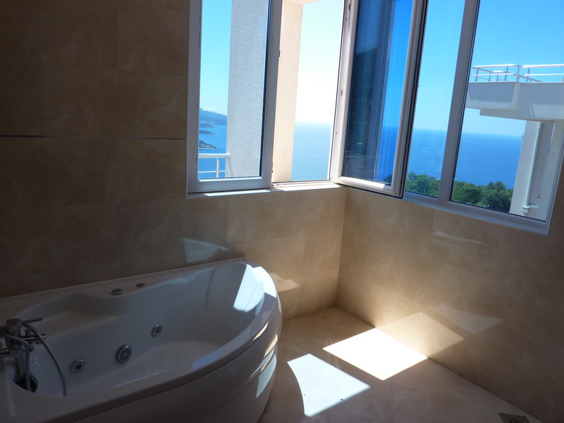 Bathroom with a jacuzzi and panoramic sea view in a villa, Dobrota, Montenegro. Bright tiled finish.