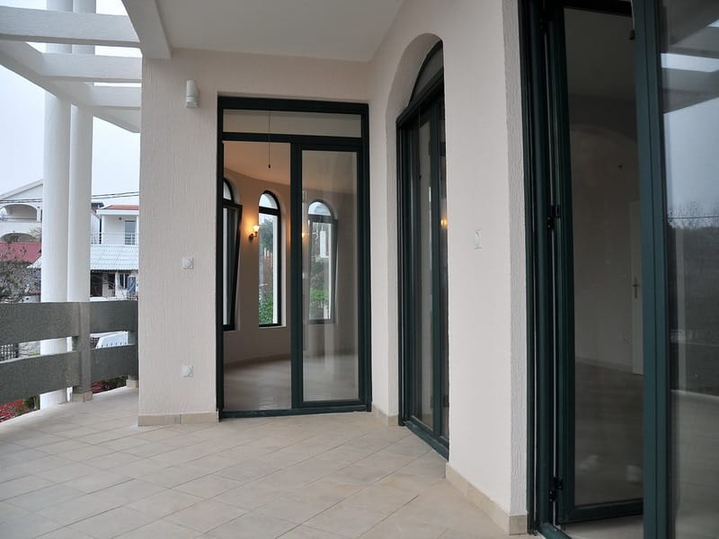 Spacious terrace with panoramic windows in a house, Utjeha, Montenegro: bright finishes and views of the surroundings.