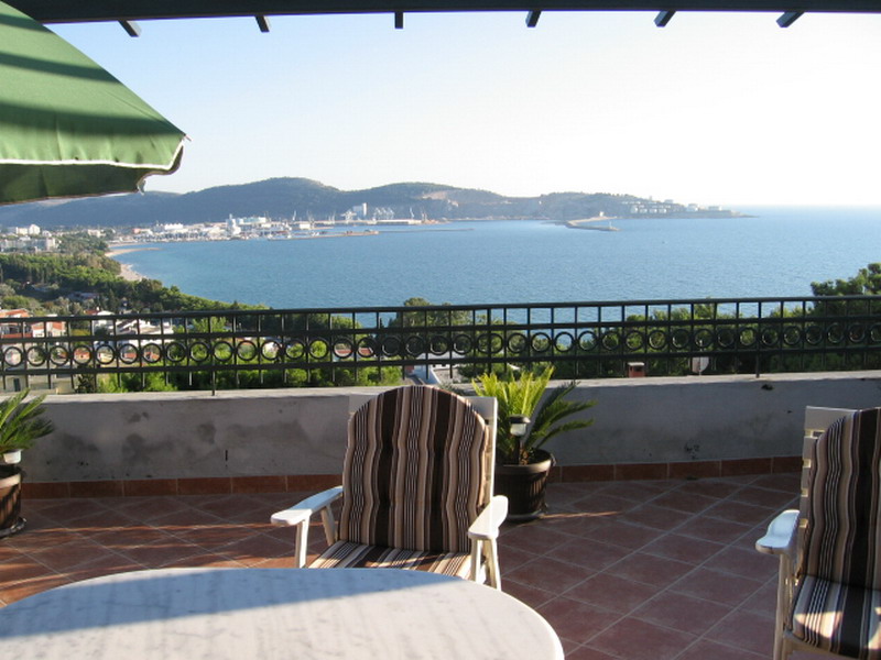 Terrace with sea and port views in a house in Bar, Montenegro: garden furniture, tile flooring, panoramic sea view.