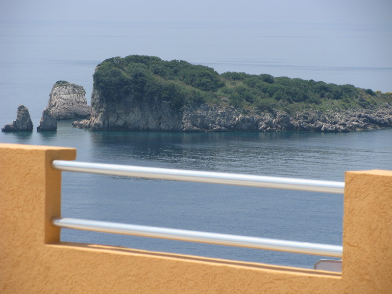 View from the balcony of a house in Utjeha, Montenegro: a panorama of the Adriatic Sea and a picturesque rocky island with greenery.