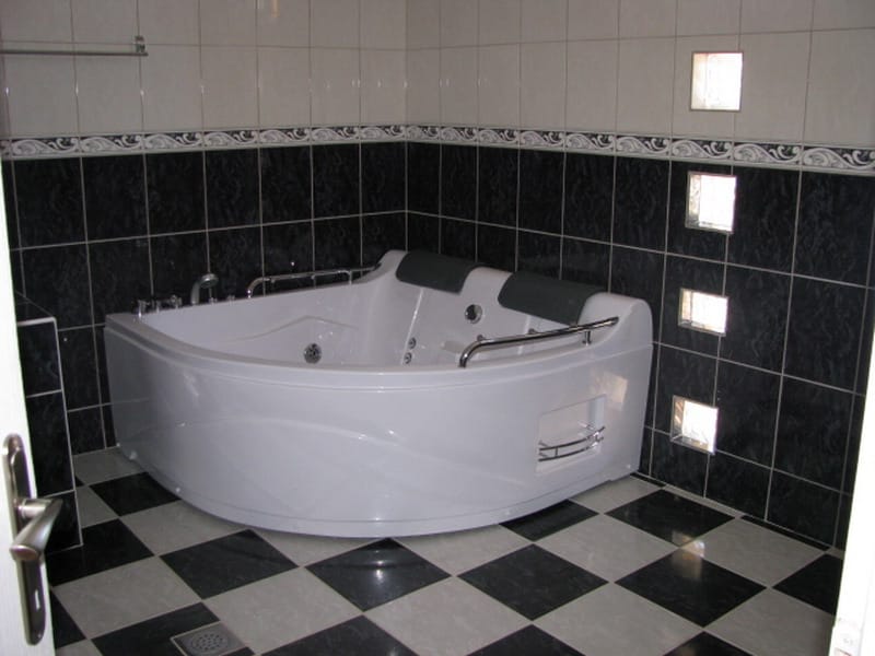 Bathroom with corner jacuzzi and black-and-white tile in a house for sale, Utjeha, Montenegro.