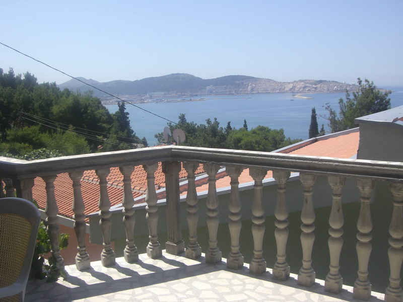 View from a balcony with a stone balustrade of the sea and mountains in a house in Shushan, Montenegro.
