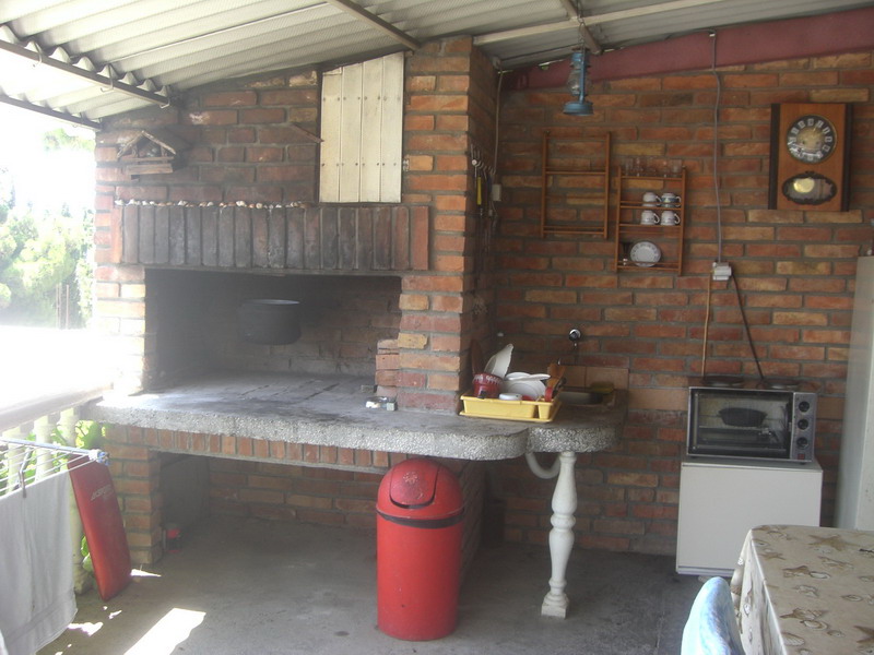 Summer kitchen with a brick barbecue and cooking area on the covered terrace of a house in Shushan, Montenegro.