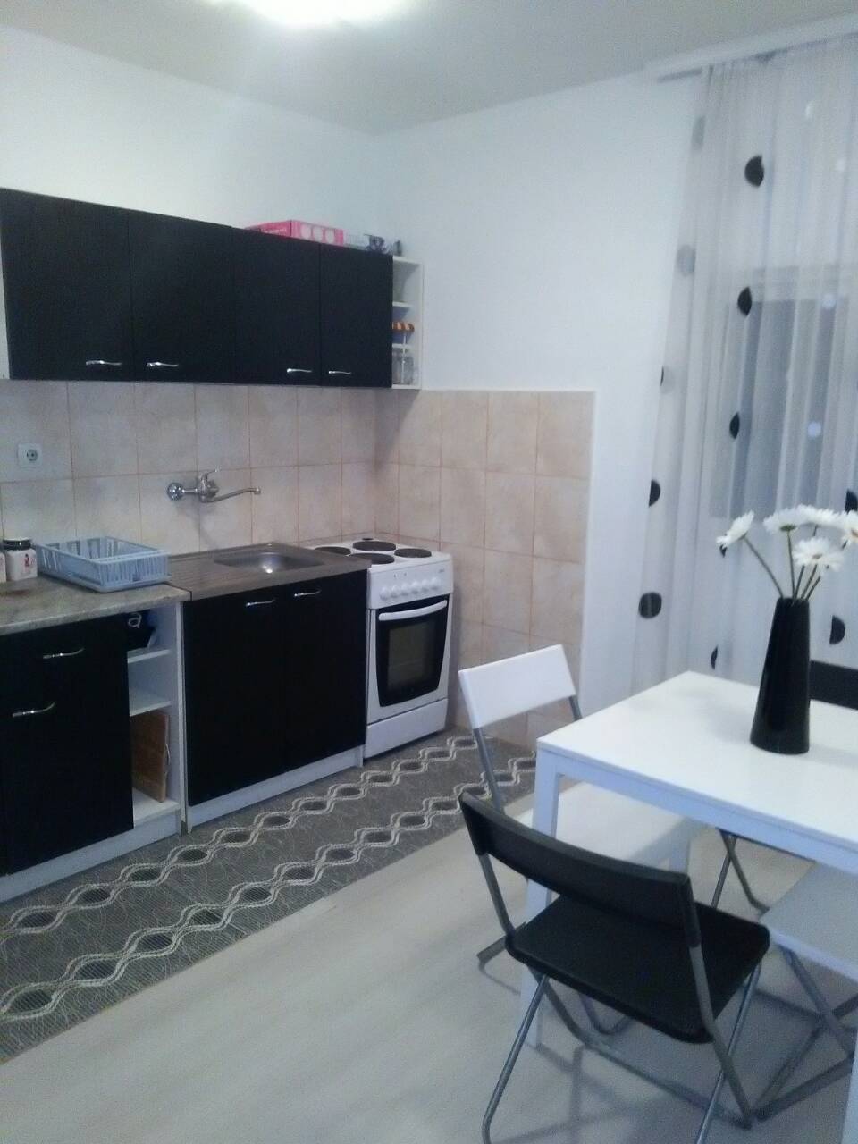 Kitchen with black cabinetry and a dining area in a house, Shushan, Montenegro. Bright interior with modern appliances.
