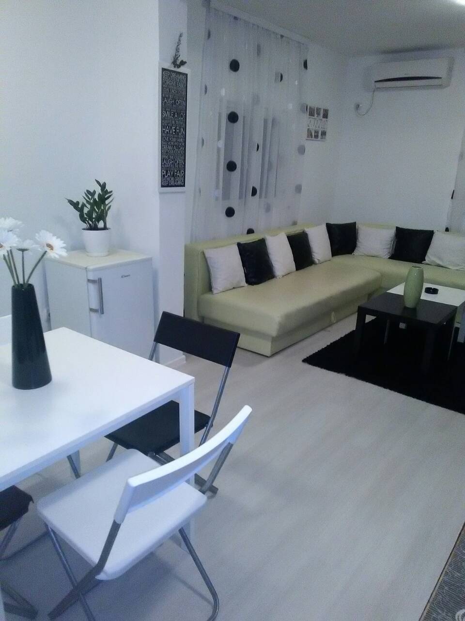 Bright living room with an L-shaped sofa and dining area in a house, Shushan, Montenegro. Modern interior with air conditioning.