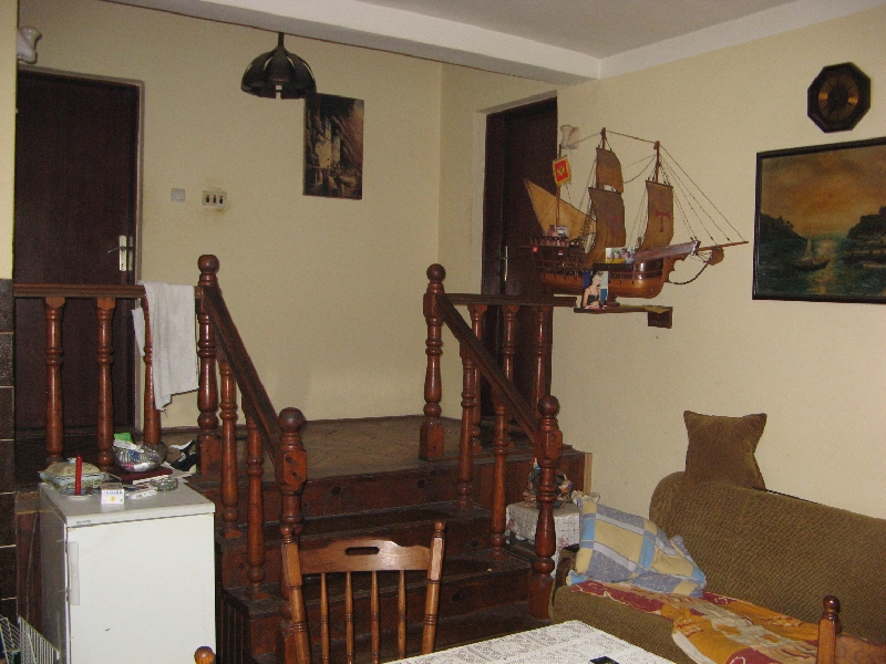 Living room in a house in Shushan, Montenegro: wooden staircase, upholstered furniture, sailboat decor, and classic finishes.