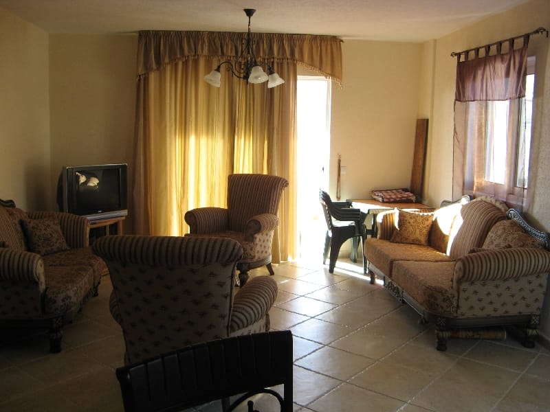 Cozy living room with soft furniture and access to the terrace in a house, Uteha, Montenegro. Bright interior with tile flooring.