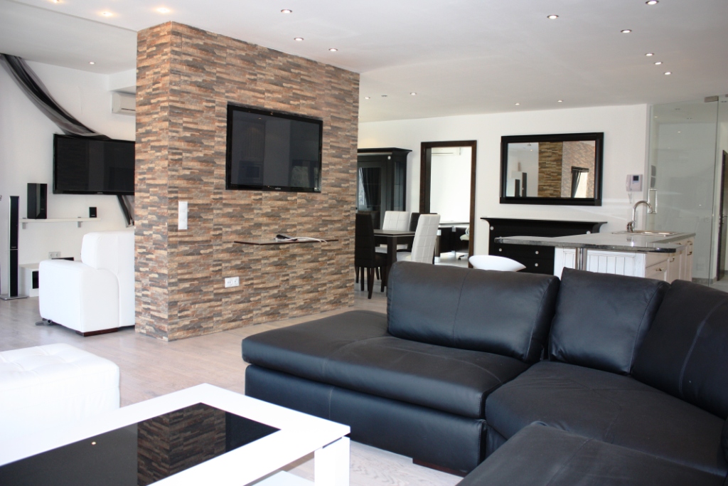Modern living room with stone finishes and a leather sofa in an apartment in Bečići, Montenegro.