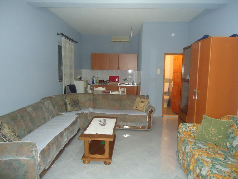 Living room with soft furniture and kitchen in a house for sale, Shushan, Montenegro: interior with a sofa and dining area.