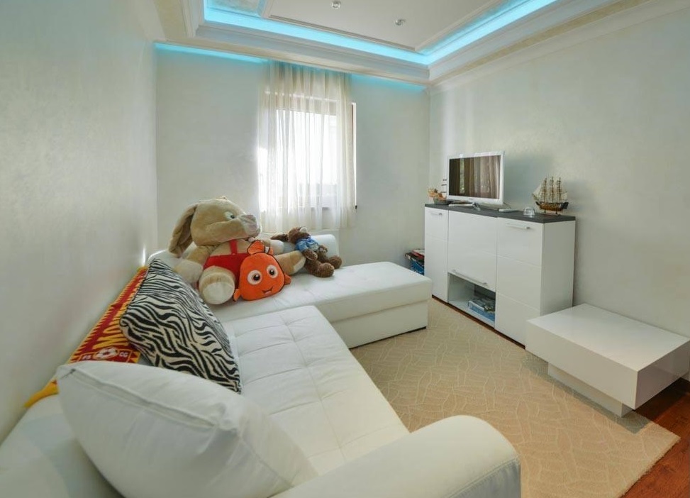 Bright living room with a white sofa and ceiling lighting in a villa in Herceg Novi, Montenegro.