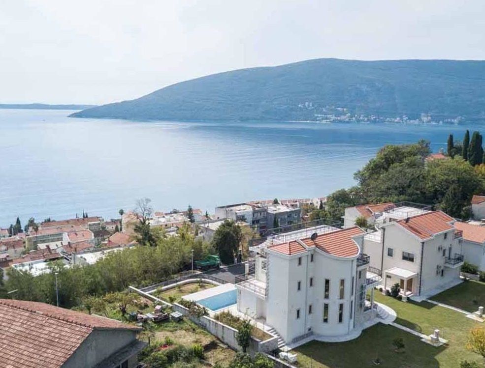 Villa with a pool and panoramic sea view in Herceg Novi, Montenegro: view of the house with a terrace and green grounds.