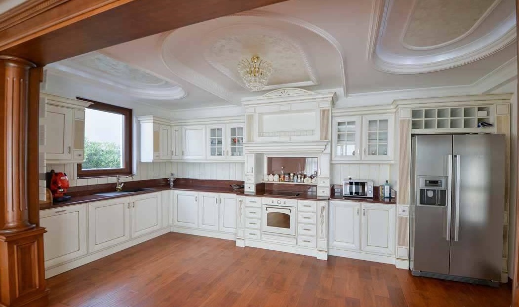 Classic light-toned kitchen with wooden flooring in a villa in Herceg Novi, Montenegro: built-in appliances and decor.
