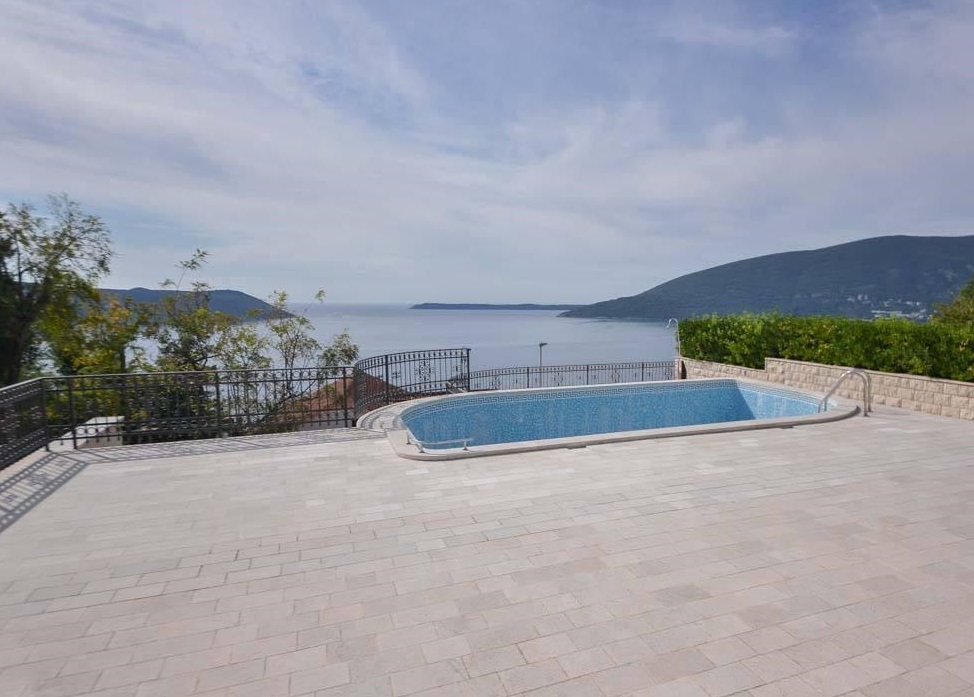 Open-air pool on the villa terrace in Herceg Novi, Montenegro, with panoramic views of the Adriatic Sea and mountains.